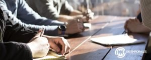 Equipo de trabajo tomando notas durante una reunión